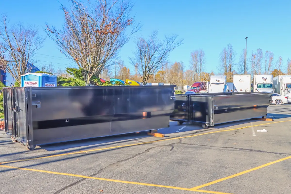 Professional dumpster rental service with roll-off container on residential driveway in Woodlawn